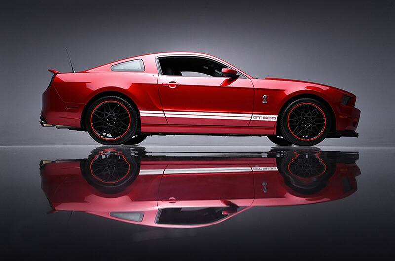 Red 2013 GT500 Mustang in studio with reflection underneath